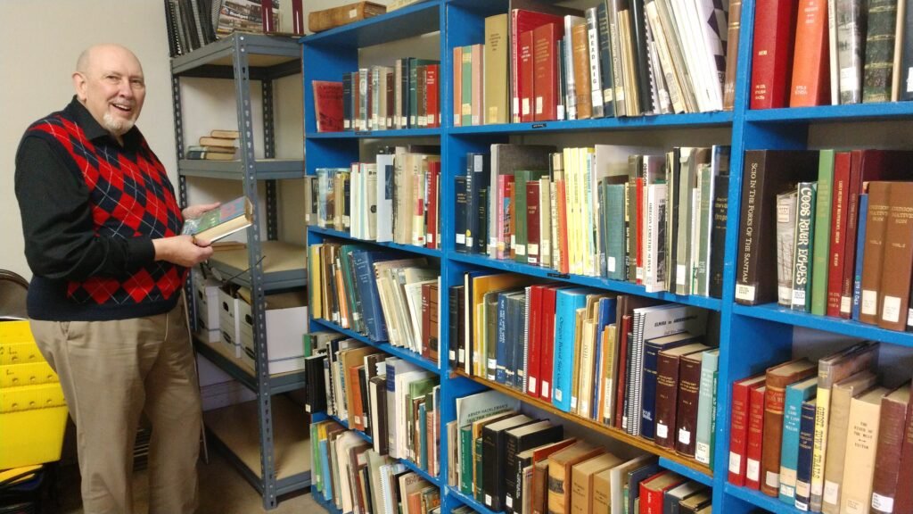 Richard stands in front of some of the shelves holding the Oregon Collection at the Carnegie library